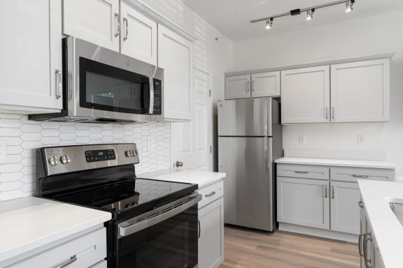 a kitchen with white cabinets and stainless steel appliances at The Charleston, Columbus, OH, 43221