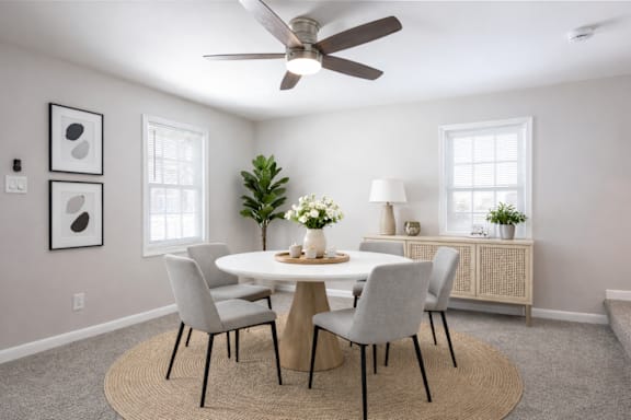 A dining room with a round table and chairs.