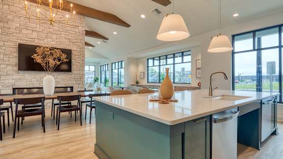 a kitchen with a large island and a dining room with a table and chairs at Allure at Edinburgh, Virginia, 23322