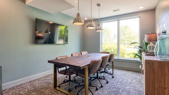 A conference room with a long table and chairs.