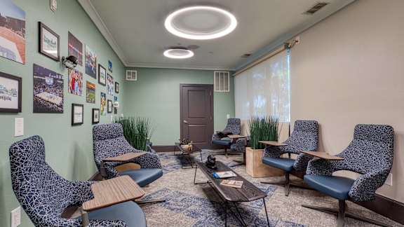 A room with blue chairs and pictures on the wall.