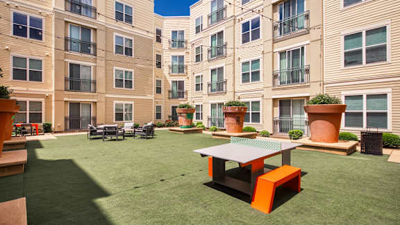 A large grassy area with a table and chairs in the middle of it.