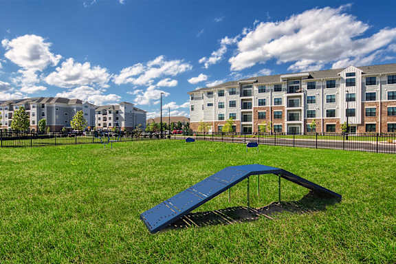 A playground with a blue slide in front of apartment buildings at Allure at Edinburgh, Chesapeake, VA