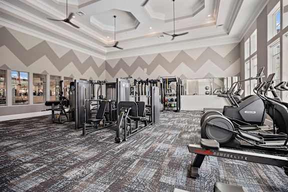 A gym with a variety of equipment including treadmills, weights, and exercise machines at Ellis Station, Durham, 27703