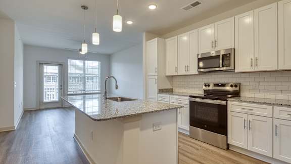 A kitchen with white cabinets and a granite countertop at The Walker Virginia Center, Glen Allen, Virginia 23059