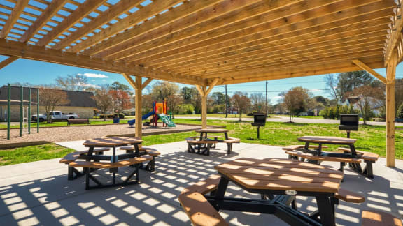 two picnic tables under a wooden pavilion in a park at Bayville Apartments, Virginia Beach
