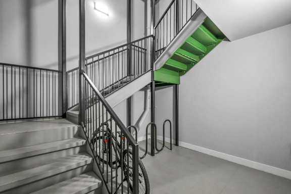 A staircase with a metal railing and a green staircase.