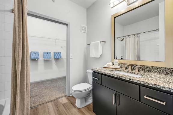 A bathroom with a toilet, sink, and mirror.