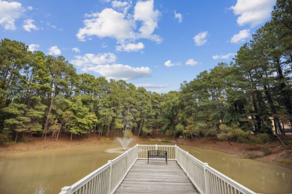 a bridge over a body of water with a bench on it at Shellbrook, Raleigh, 27609