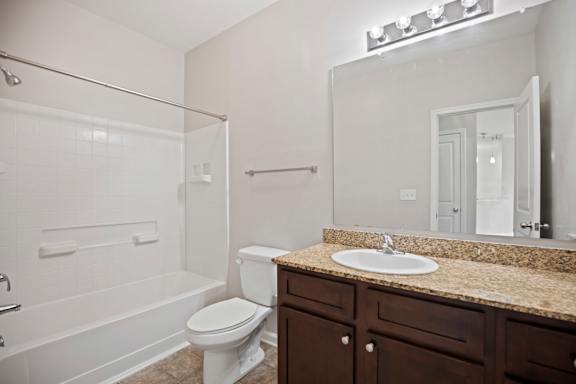 A white toilet sits next to a sink in a bathroom.