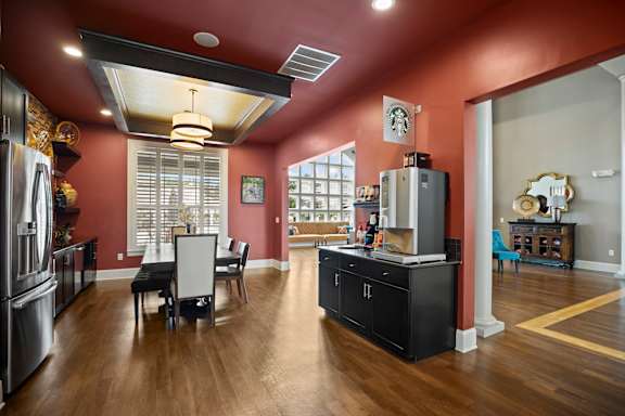 A kitchen with a black countertop and a refrigerator.