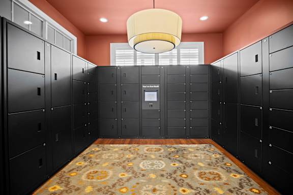 A hallway with a rug and a chandelier hanging from the ceiling.