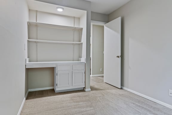 a bedroom with a desk and shelves