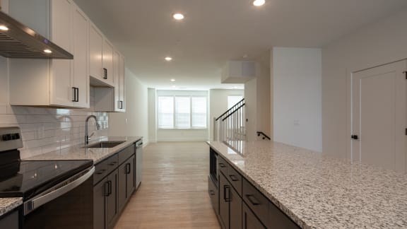 a kitchen with white cabinets and granite countertops at Ainsworth, Virginia
