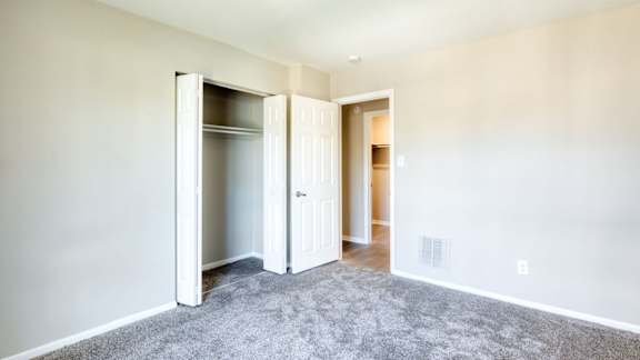 an empty bedroom with a closet and a door open at Bayville Apartments, Virginia Beach, Virginia