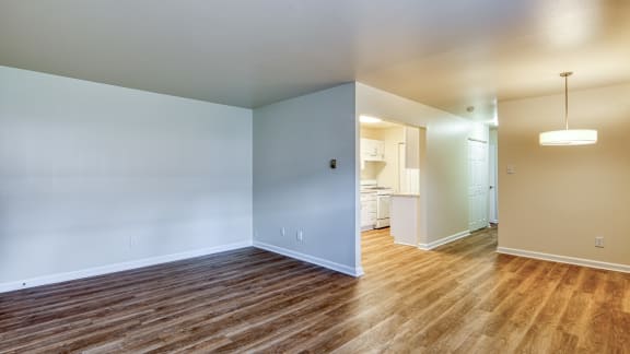 an empty living room with wood flooring and a renovated kitchen at Gates of West Bay in Virginia 23503