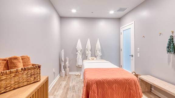 A room with a bed and a basket on a table.