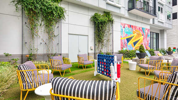 A white building with a mural and a striped couch at Mosaic Summit Pointe in Chesapeake, VA, 23320