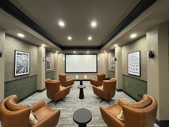 A room with a screen and chairs.