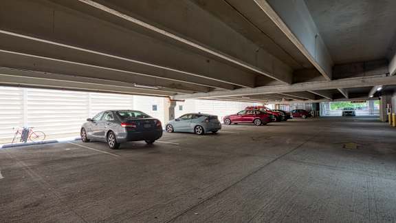 Three cars are parked in a parking garage.