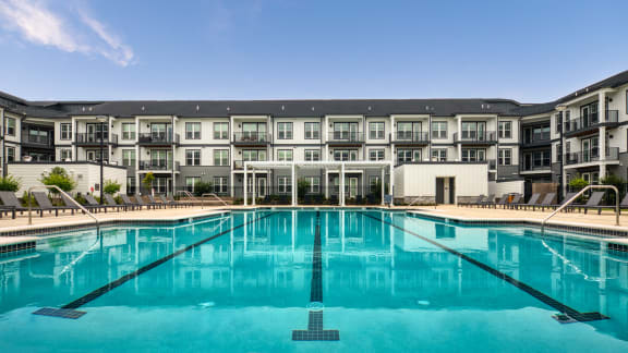 a swimming pool with an apartment building in the background at Ainsworth, Richmond, Virginia