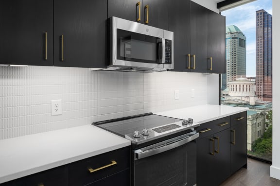 a kitchen with black cabinets and white countertops at Preston Centre, Columbus, OH