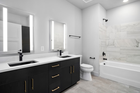 a bathroom with black cabinets and a white bathtub at Preston Centre, Ohio