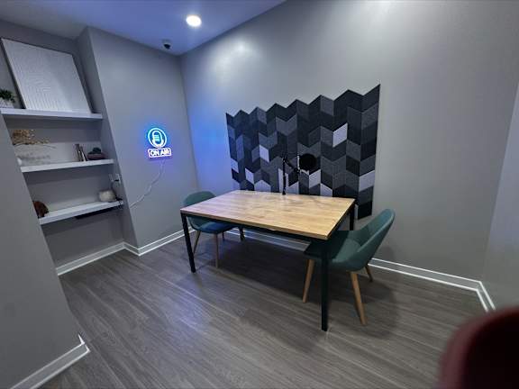 A room with a table and chairs and a blue light on the wall.