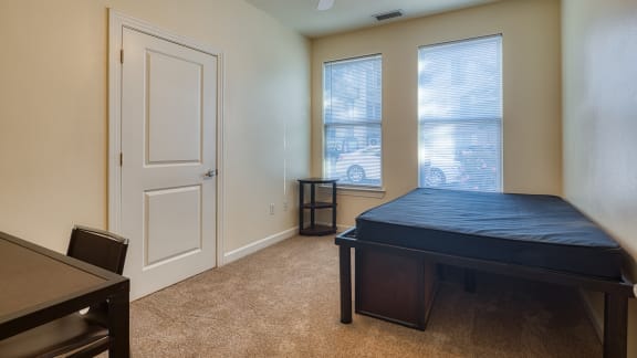 an empty room with a bed and a table at Proximity at ODU in Norfolk, 23508