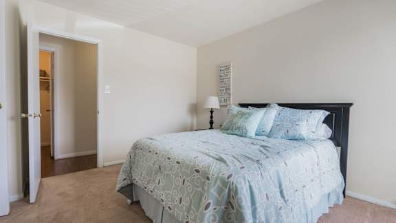 a bedroom with a bed and a door to a bathroom  at Bayville Apartments, Virginia, 23455