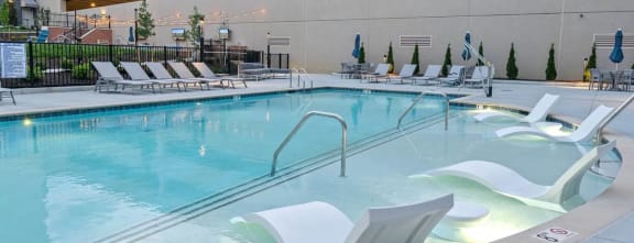 a swimming pool at a hotel with chairs around itat Metropolis Apartments, Glen Allen, VA