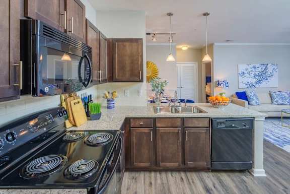 A modern kitchen with dark wood cabinets and a black stove top oven.
