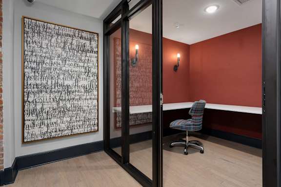 A room with a chair and a painting on the wall.