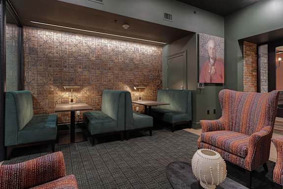 A room with a brick wall and a row of chairs.