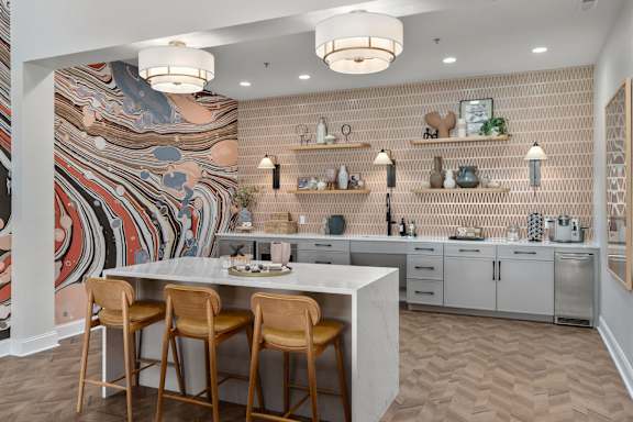 A kitchen with a large mural on the wall and a marble island with three chairs at The Orchard, Ohio, 43016