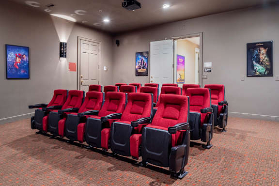 A row of red and black cinema seats are empty and facing a screen at The Orchard, Ohio, 43016