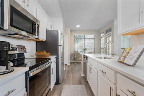 A modern kitchen with white cabinets and a wooden floor at The Orchard, Dublin, OH, 43016
