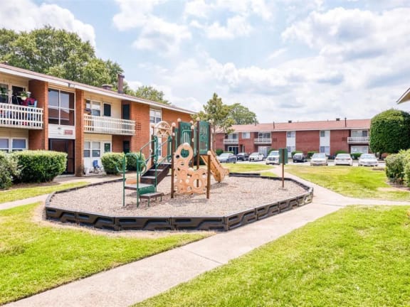a playground in the middle of an apartment complex with a swing set