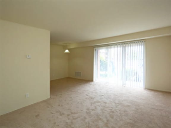 an empty living room with a sliding glass door to a patio at Gates of West Bay in Norfolk, VA 23503
