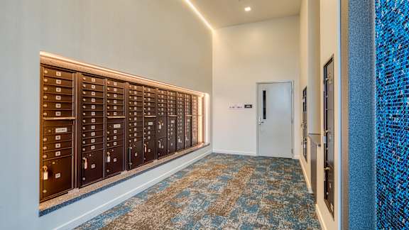 A hallway with a row of mailboxes on the wall at Mosaic Summit Pointe in Chesapeake, Virginia