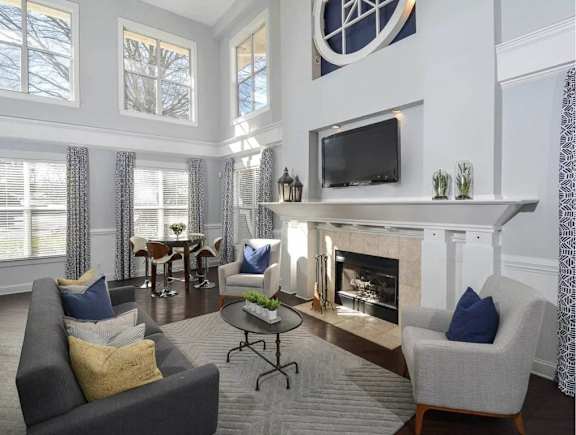 A living room with a grey couch, a fireplace, and a television.