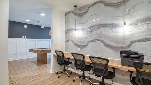 A conference room with a marble wallpaper and a printer on the desk.