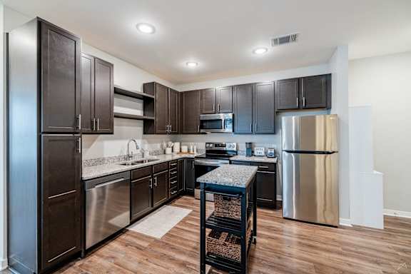 A kitchen with dark wood cabinets and stainless steel appliances.