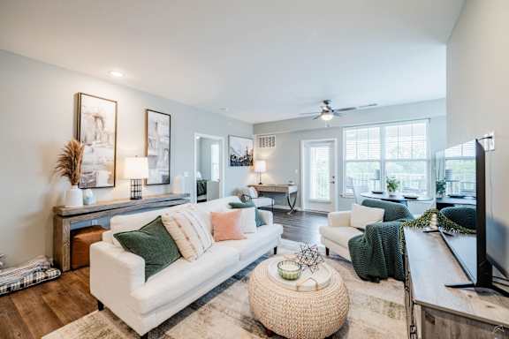 A living room with a white couch and a wooden coffee table.