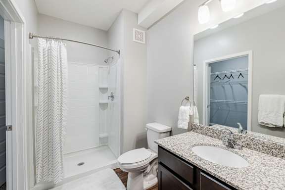 A bathroom with a toilet, sink, and shower.