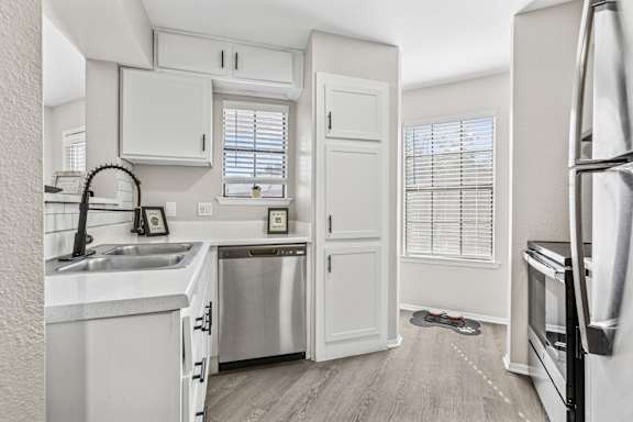 Compact kitchen with subway tile backsplash and pantry door at Polo Club Apartments, Austin, Texas
