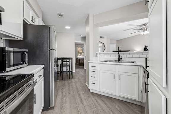 Modern kitchen with island and black faucet at Polo Club Apartments, Texas