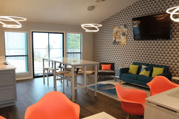 Community room with modern pendant lighting and vibrant furniture at Peaks at Live Oak Apartments, San Antonio, 78233