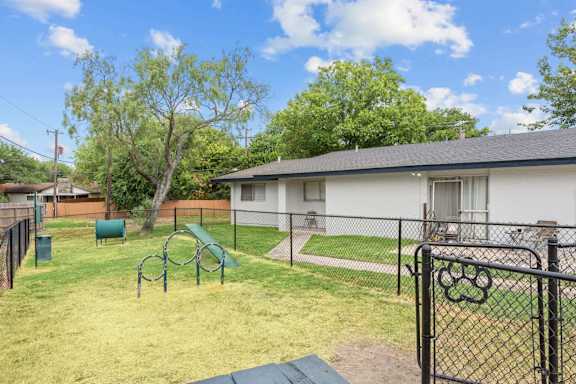 Pet friendly backyard with fenced dog run and agility hoops at Peaks at Live Oak Apartments, San Antonio, TX