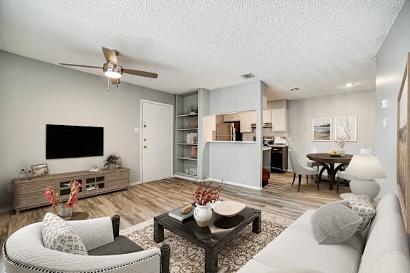 Modern living space with open floor plan and natural wood flooring at Peaks at Live Oak Apartments, Texas
